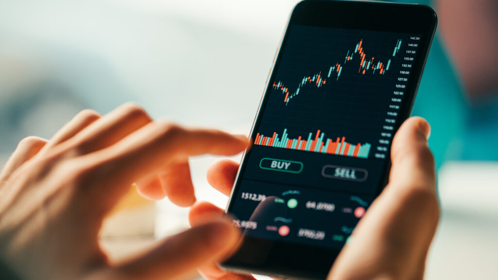 A woman using an investment app on her phone.