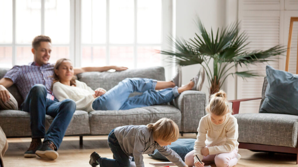 A family with young children in the living room of their home.