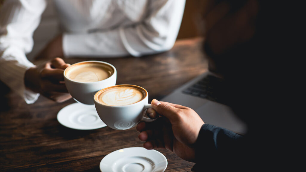 Two people holding coffee cups.