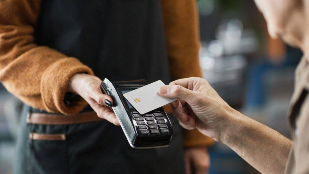 A person paying in a cafe using a contactless card.