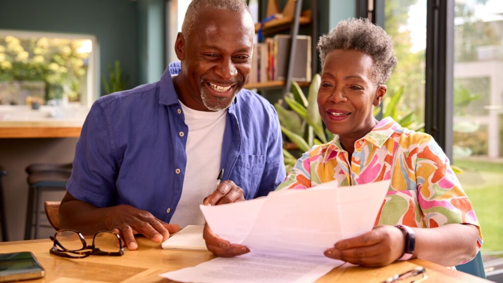 A couple reading a letter in their home.