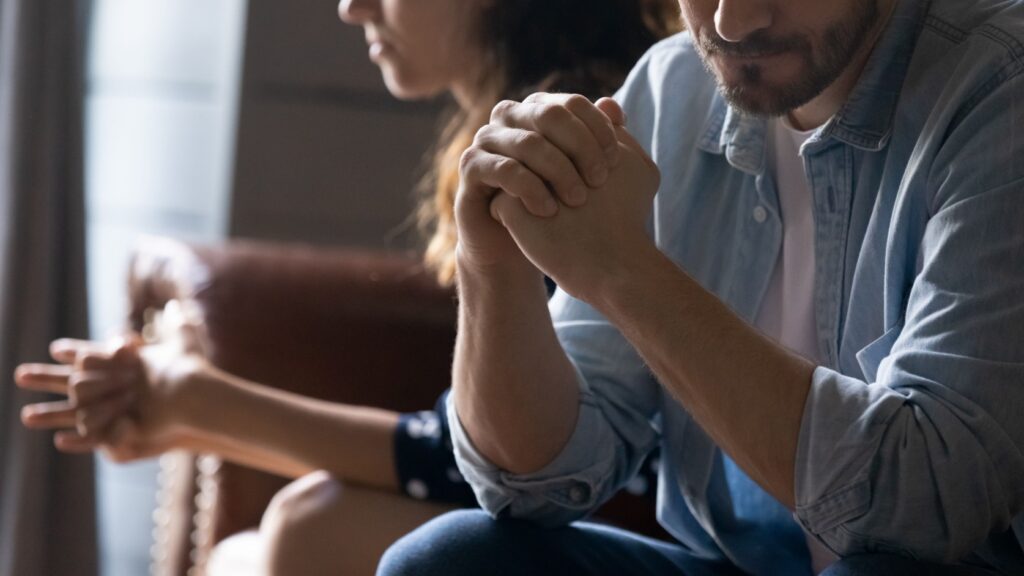 A couple after arguing sitting apart from each other.