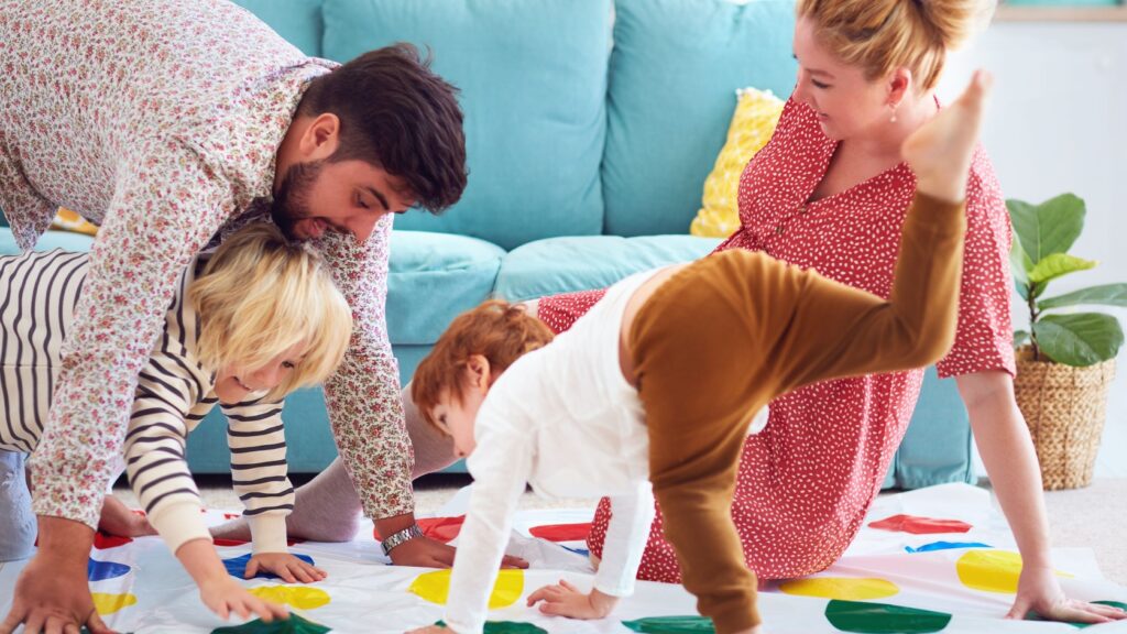 A family with young children playing Twister.