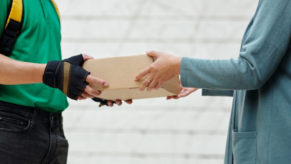 A delivery man handing a customer a parcel.