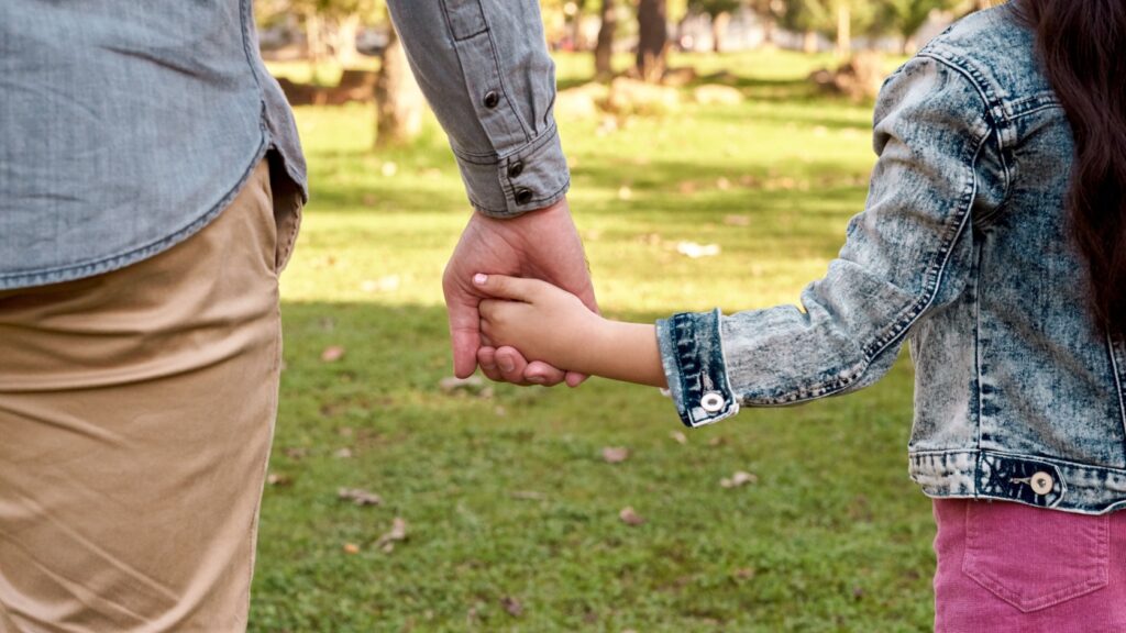 Parent and child holding hands.