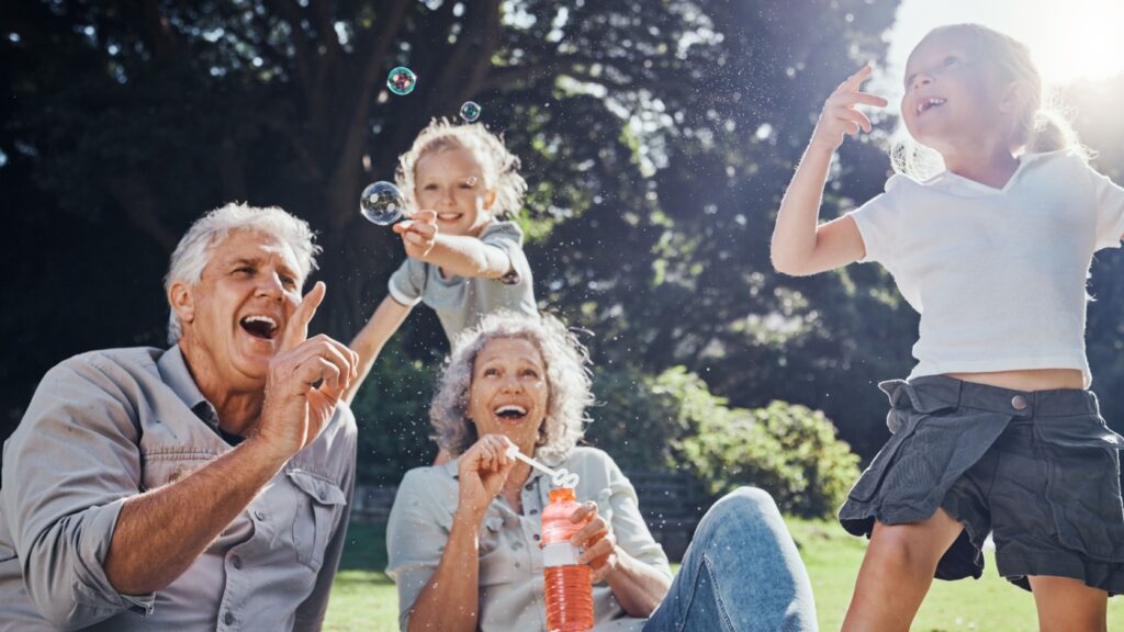 Grandparents blowing bubbles with their grandchildren.