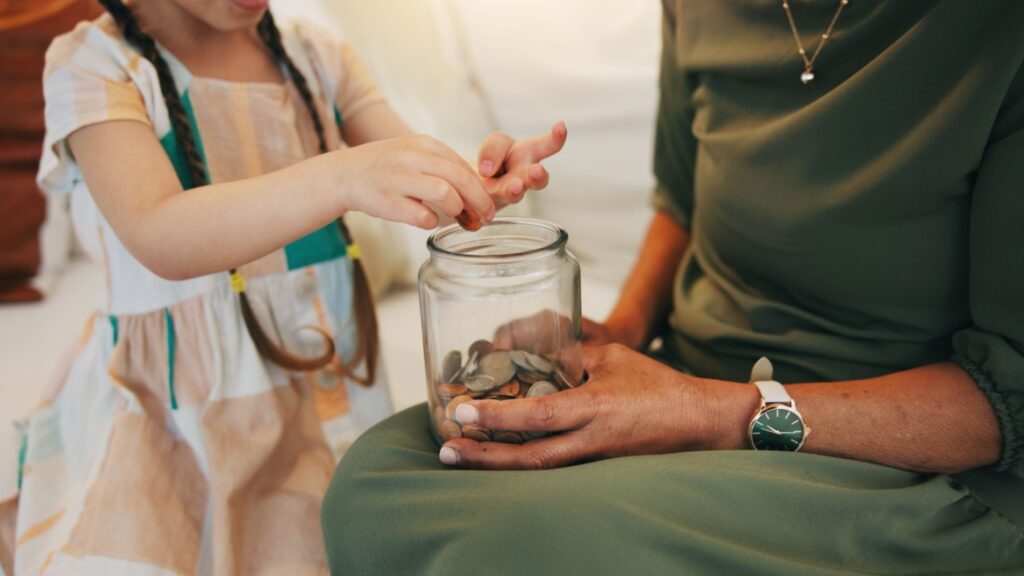 A child counting money in a jar.