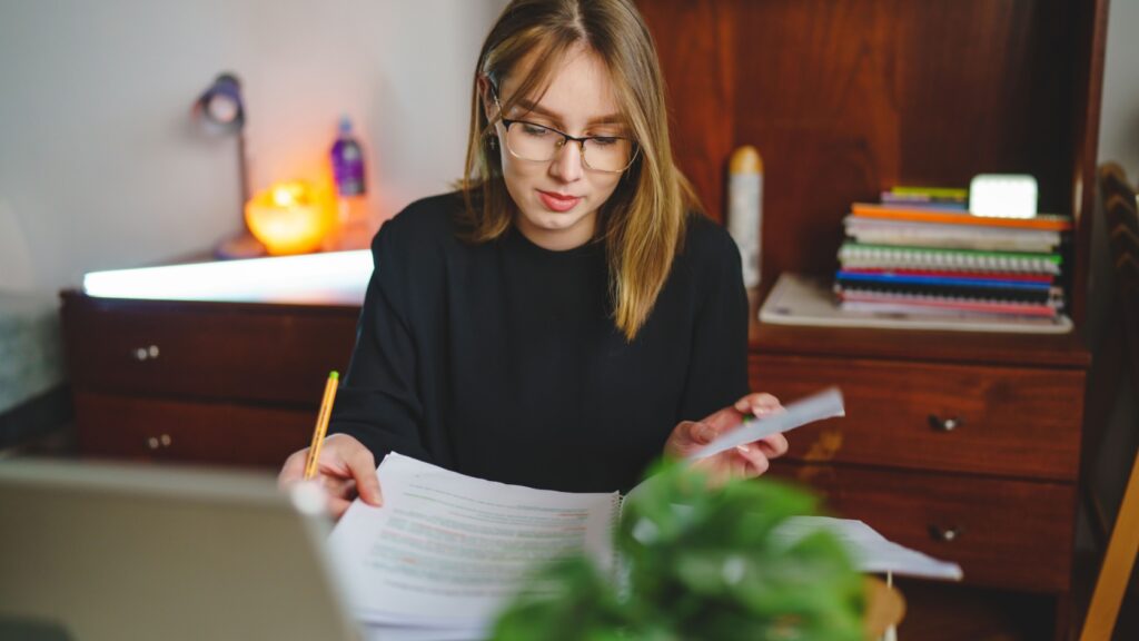 A young woman writing in a notebook.