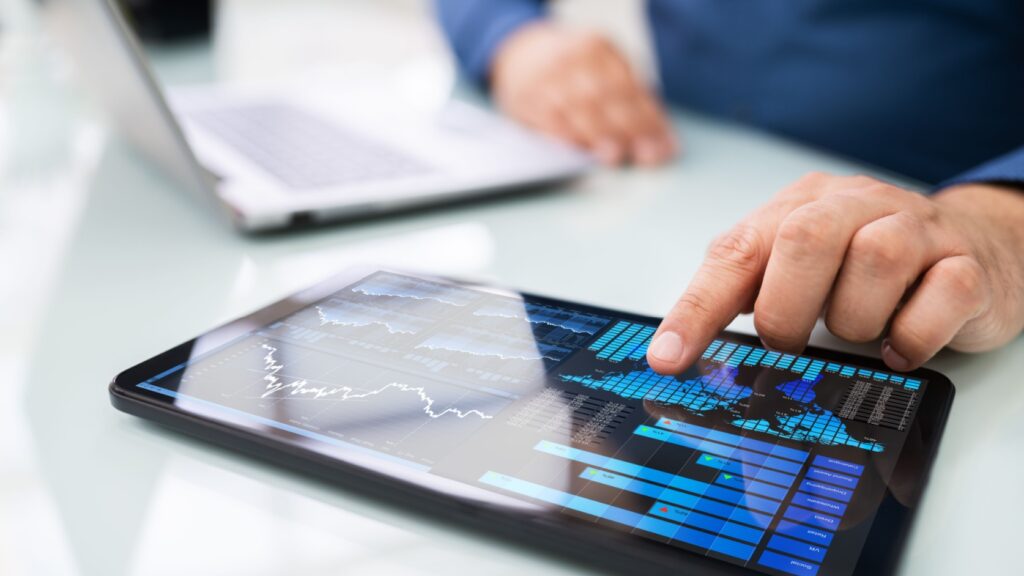 A man looking at graphs on a tablet.