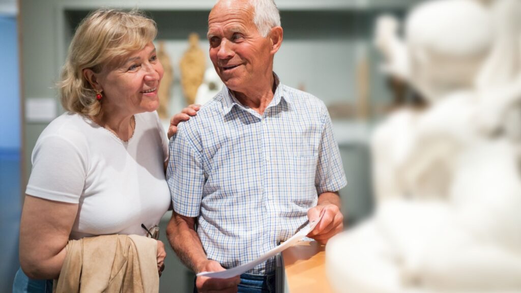 A couple looking at a statue in a museum.