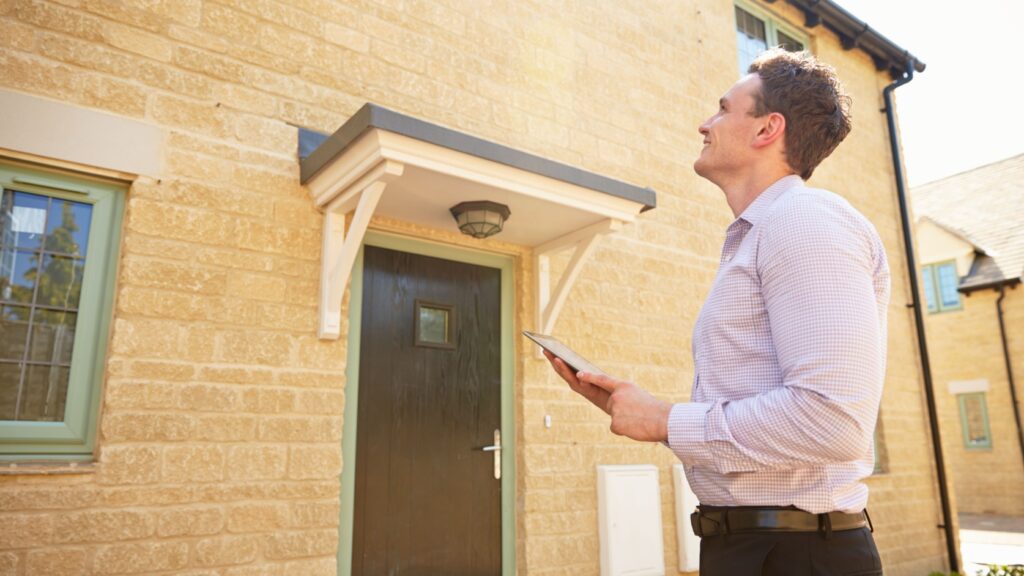 An estate agent outside of a property.