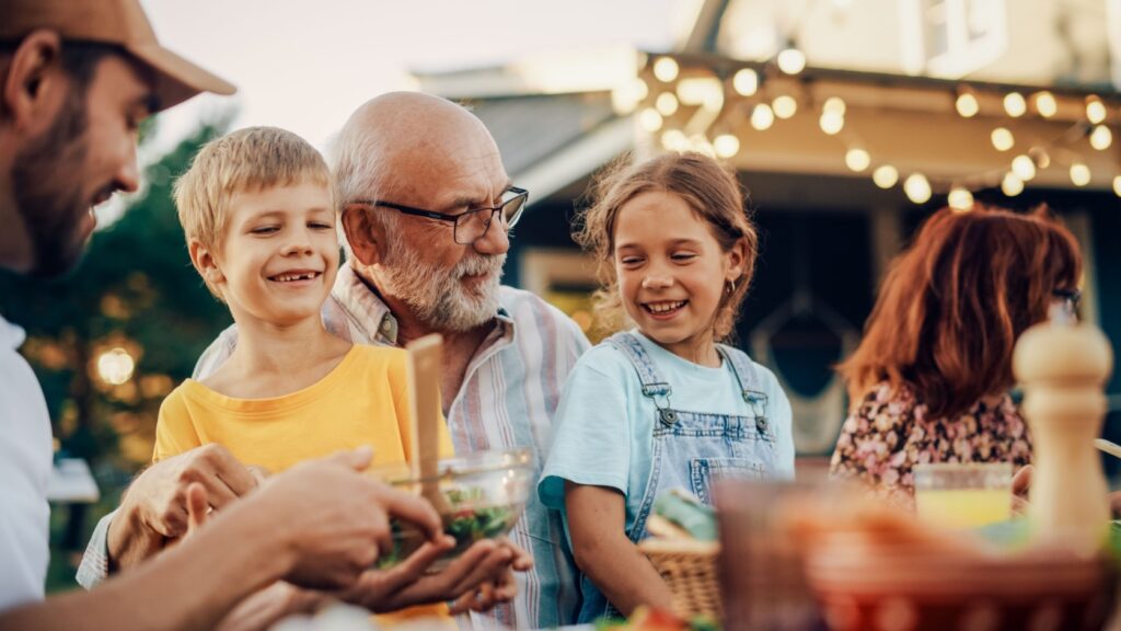 A grandfather laughing with his grandchildren.