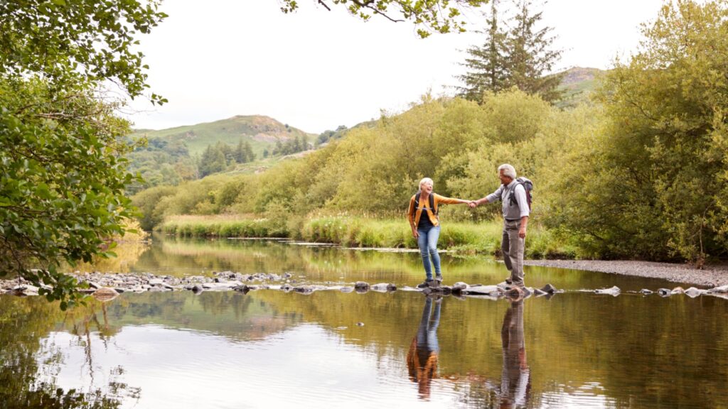A couple walking across stepping stones.