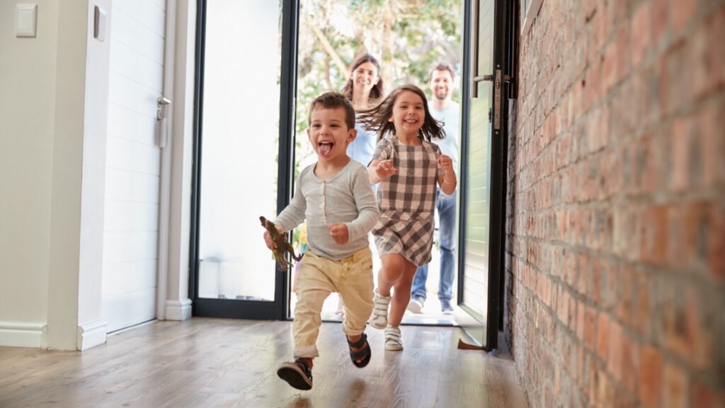 Children running through a front door.