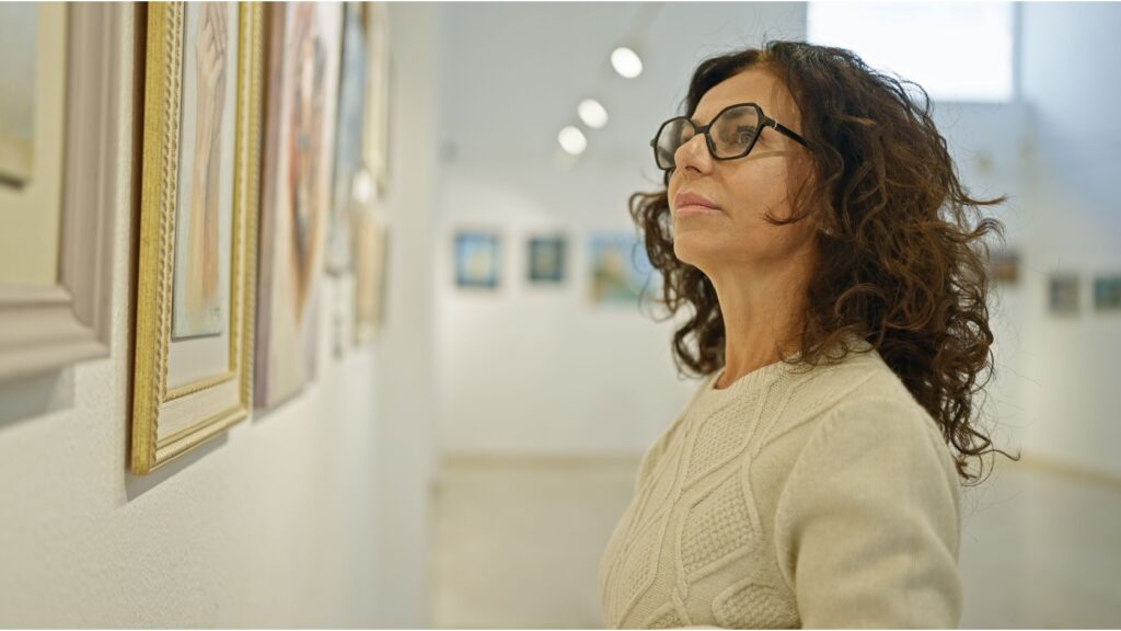 A woman looking at a painting in an art gallery.