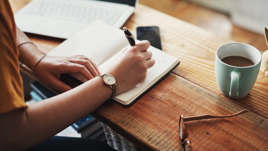 A woman making notes in a diary.