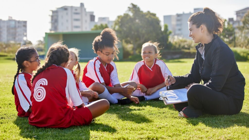A woman coaching a girl’s football team.