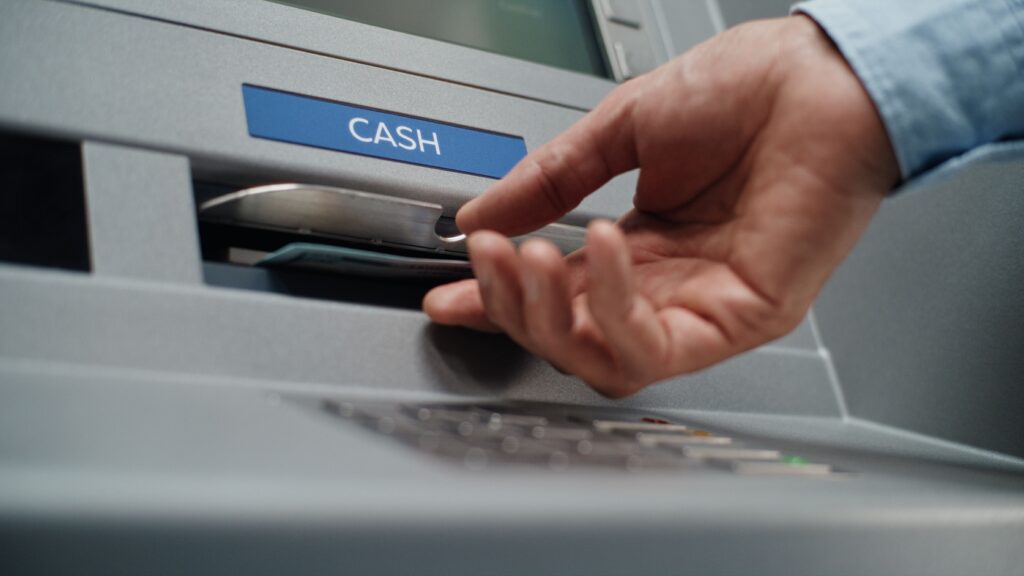 A person using an ATM to withdraw cash.