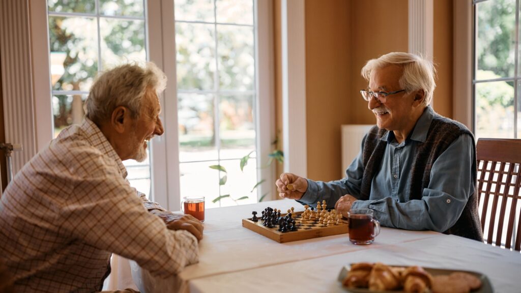 Two men playing chess at home.