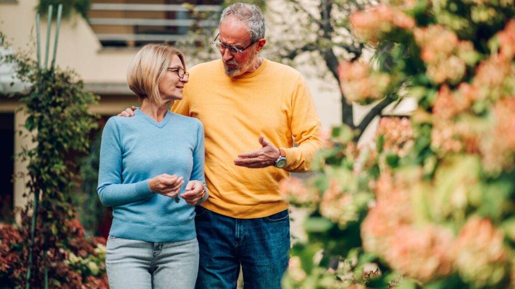 Mature couple walking outside a house