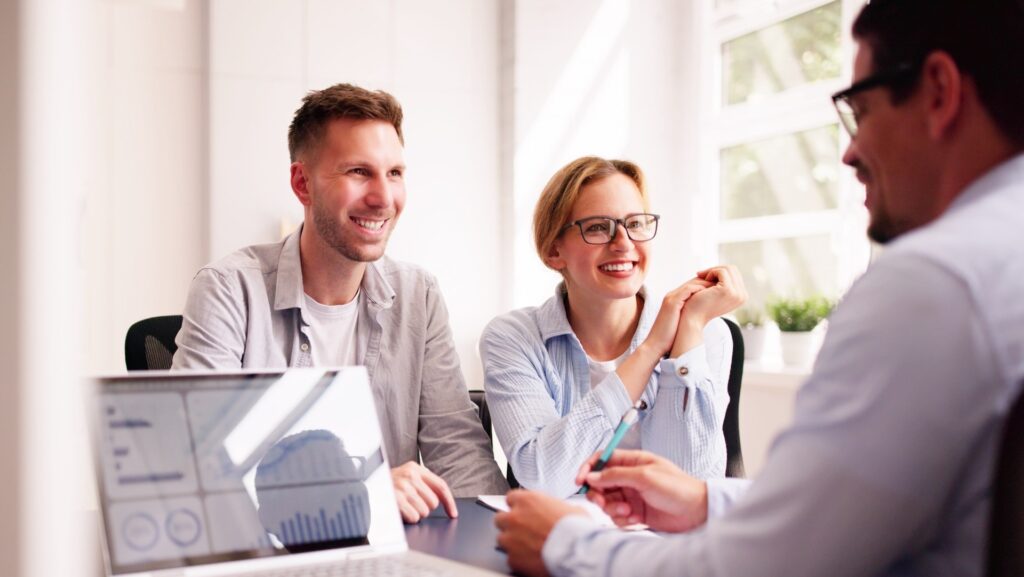 a couple happily talking to their financial planner