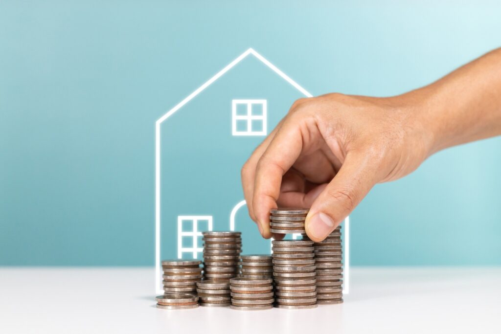 Coins next to a drawing of a home.